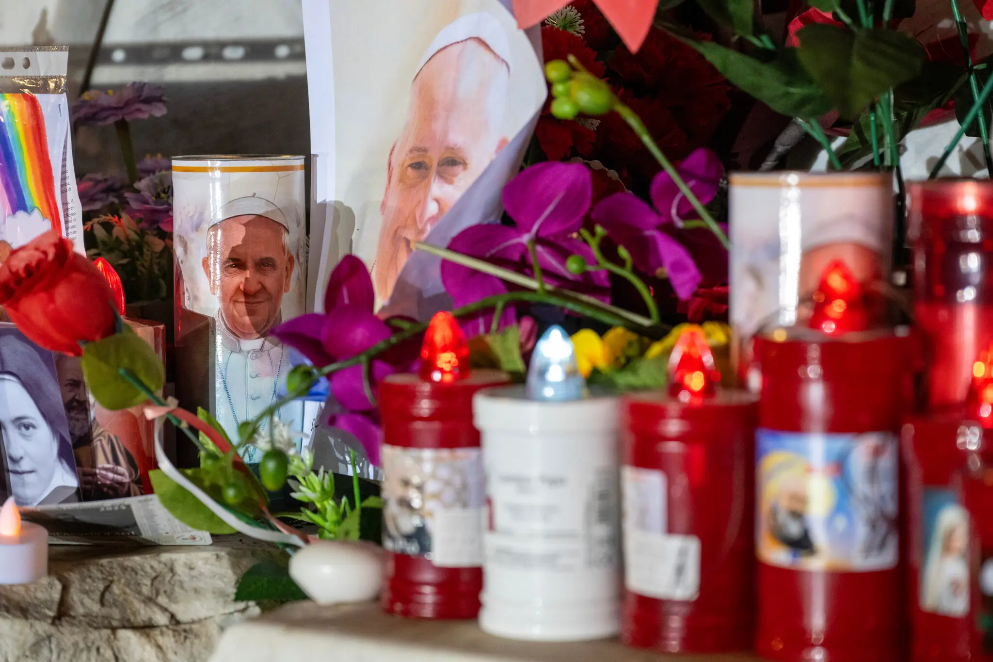 Квіти та свічки, які залишили люди, які прийшли помолитися за Папу Франциска в лікарні.